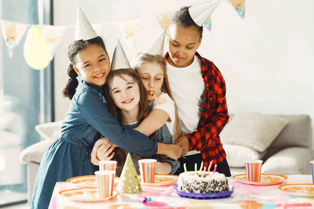 Niños celebrando un cumpleaños con gorros de fiesta, ideas de tazas para cumpleaños en San Cristóbal